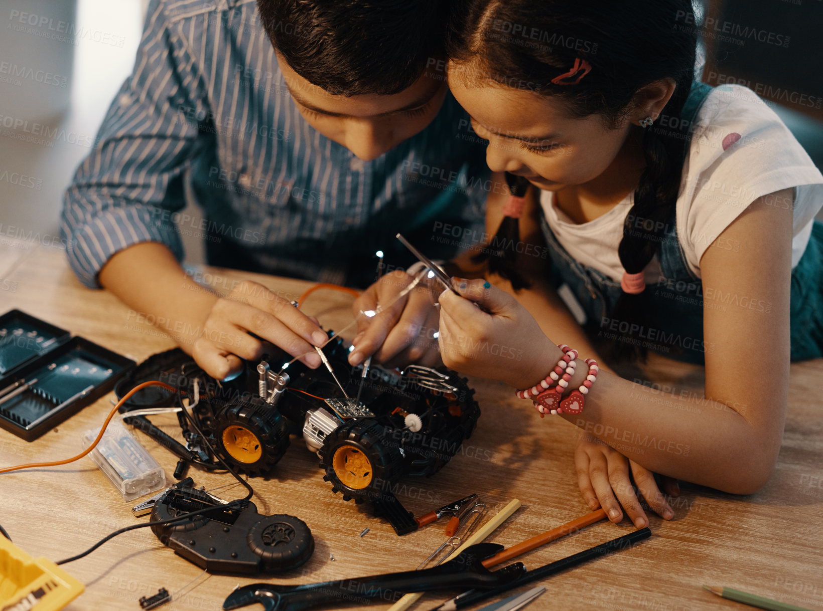 Buy stock photo Cropped shot of two adorable young siblings building a robotic toy car together at home