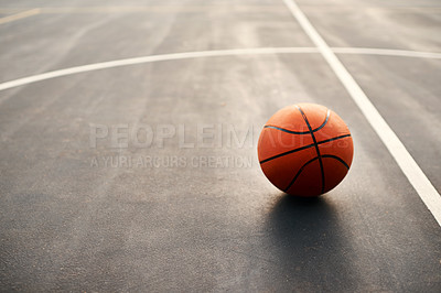 Buy stock photo Cropped shot of a basketball on empty basketball court after a match during the day
