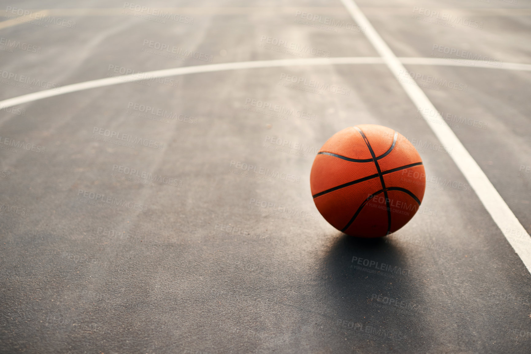 Buy stock photo Cropped shot of a basketball on empty basketball court after a match during the day