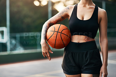 Buy stock photo Cropped shot of an unrecognizable sportswoman standing on the court alone and holding a basketball during the day