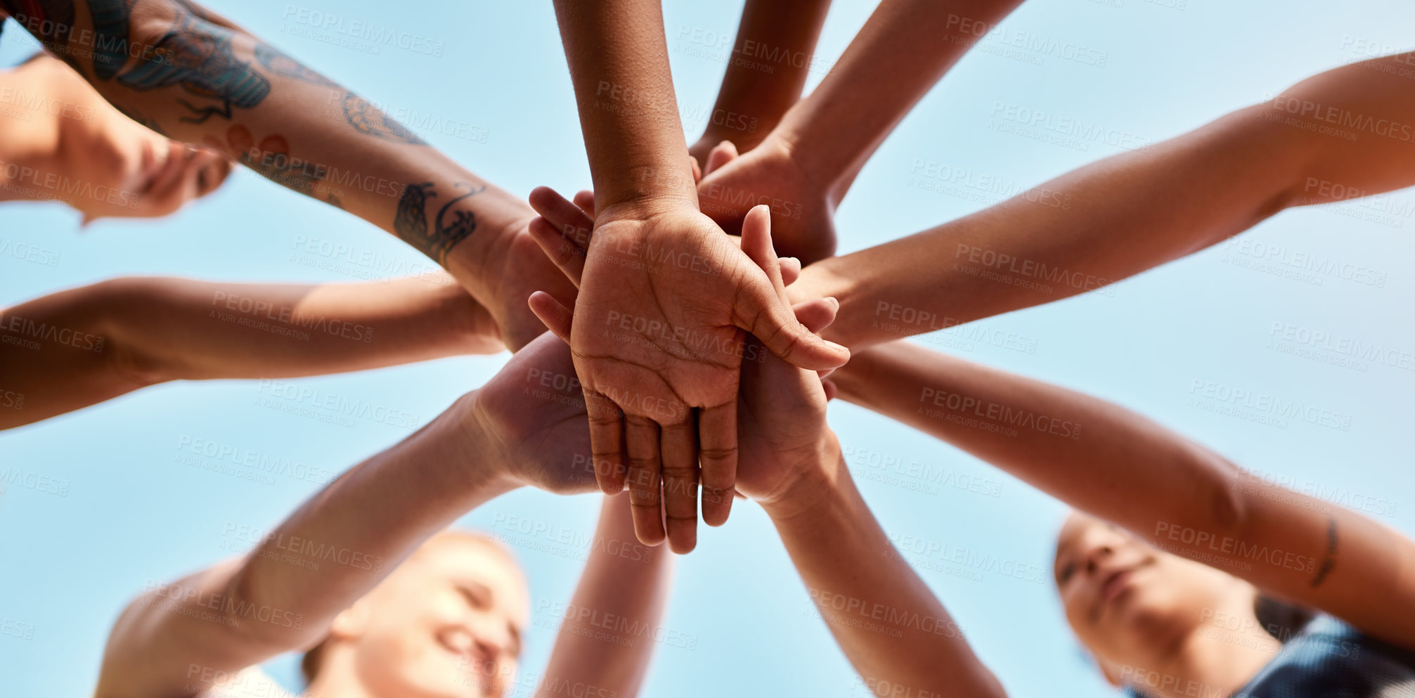 Buy stock photo Low angle shot of an unrecognizable group of sportswomen piling their hands together before a basketball game