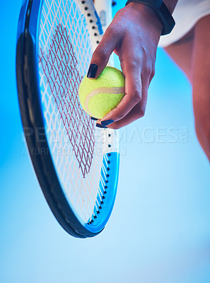 Buy stock photo Cropped shot of an unrecognizable young female tennis player getting ready to serve against a blue background