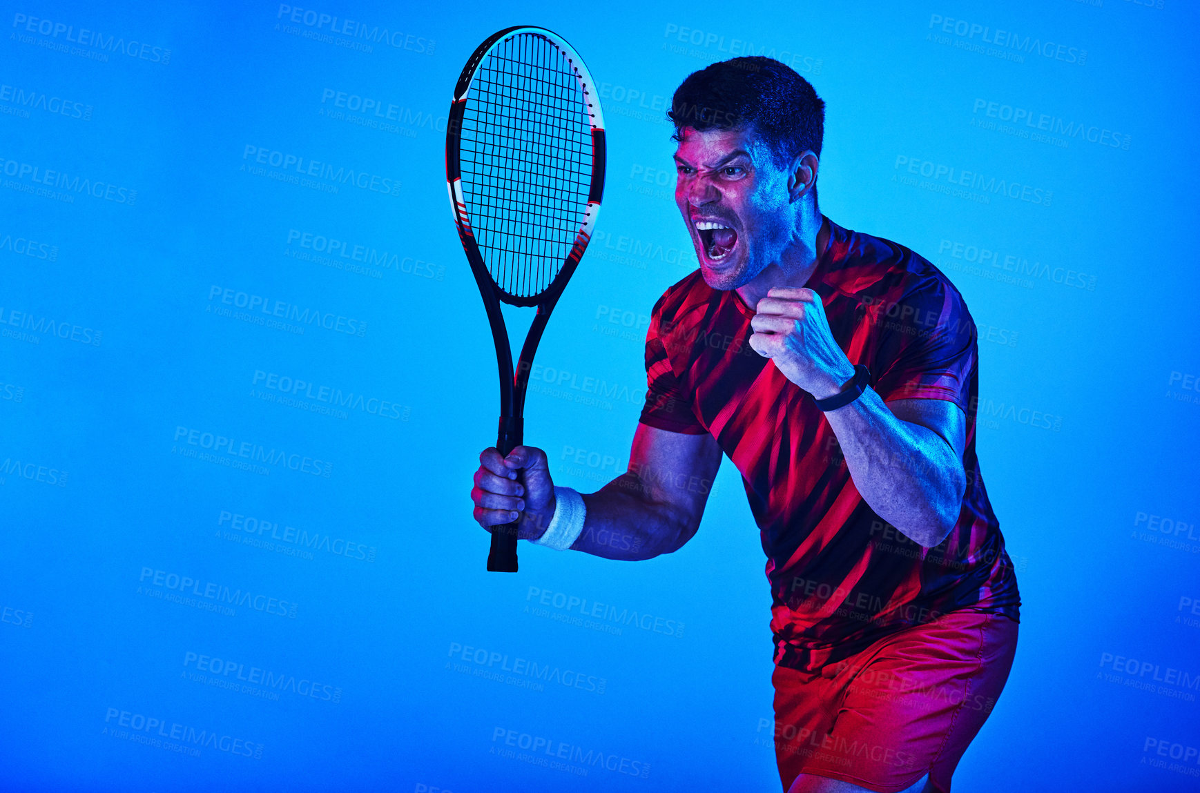 Buy stock photo Blue filtered shot of a man posing with a tennis racket in the studio