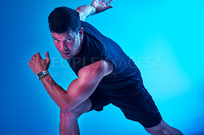 Buy stock photo Blue filtered shot of a sportsman posing in the studio
