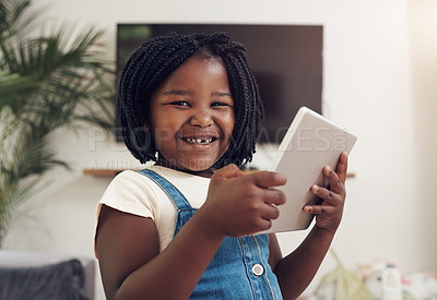 Buy stock photo Portrait of an adorable little girl having fun while using digital a tablet at home