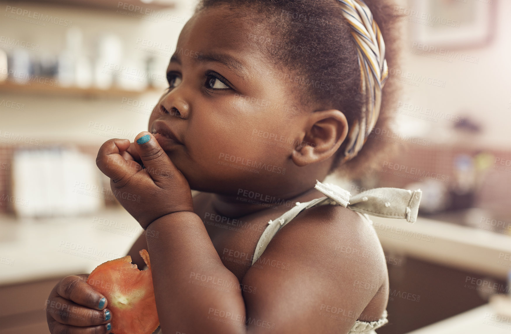 Buy stock photo Black child, tomato and eating baby in a home kitchen with food and fruit at breakfast. African girl, nutrition and youth in a house with hungry kid feeling relax with natural, healthy snack for kids
