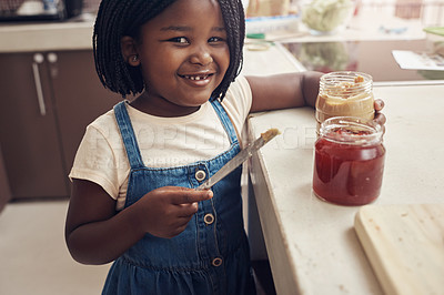 Buy stock photo Portrait of an adorable little girl making lunch for herself in the kitchen at home