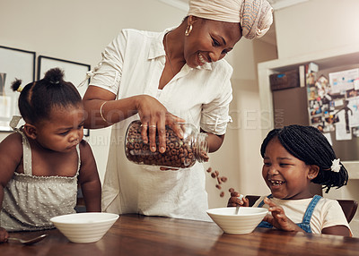 Buy stock photo Cropped shot of a young mother preparing cereal for her two adorable young daughters at home