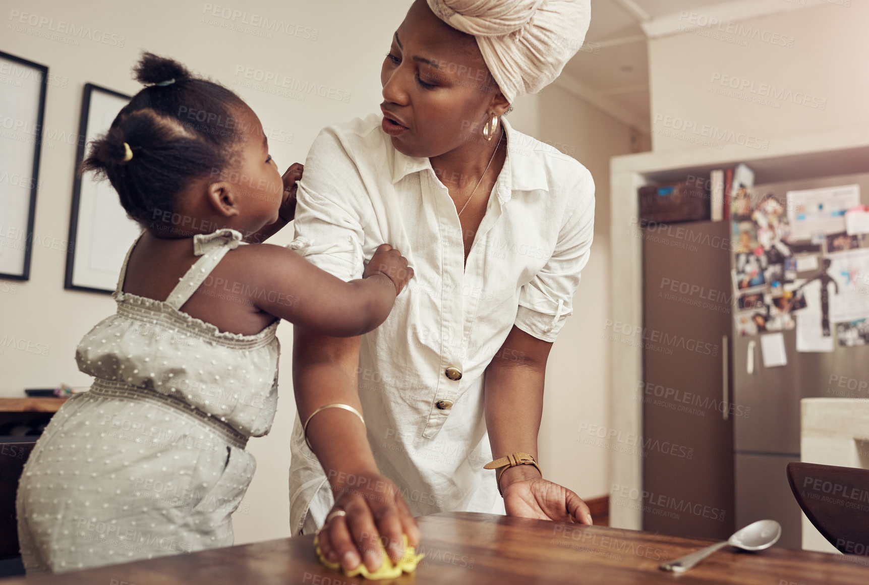 Buy stock photo Cropped shot of an adorable baby girl bonding with her mother while she cleans at home