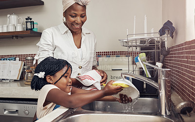 Buy stock photo Cropped shot of an adorable little girl helping her mother do the dishes at home