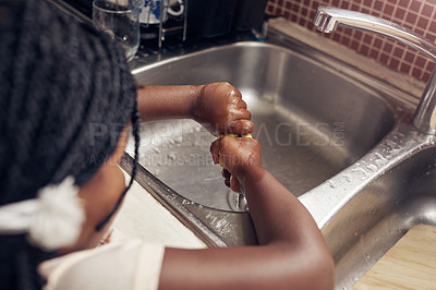 Buy stock photo Cropped shot of an adorable little girl doing the dishes in the kitchen at home