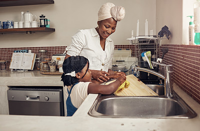 Buy stock photo Cropped shot of an adorable little girl helping her mother do the dishes at home