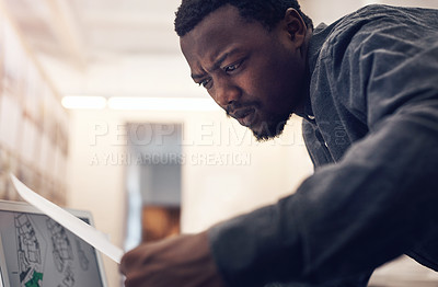 Buy stock photo Cropped shot of a handsome young male architect working with paperwork in a modern office