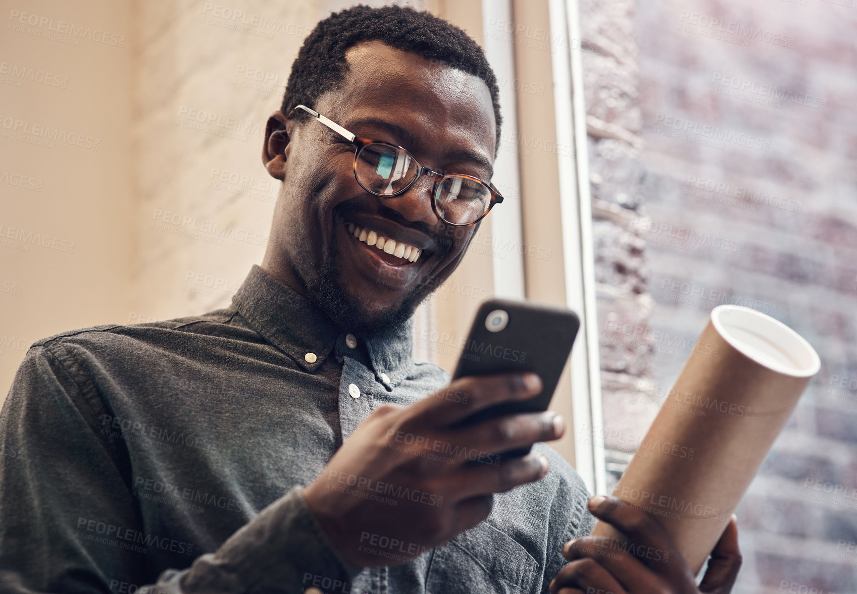 Buy stock photo Black man, happy and phone with blueprint in office for building plan, research and communication. Employee, smile and contractor with tech at work for architecture, online news and update to client