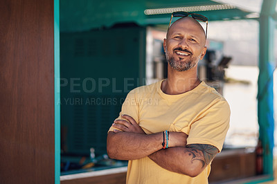 Buy stock photo Portrait of a cheerful middle aged man smiling brightly while standing outside on a beach promenade during the day