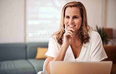 Buy stock photo Shot of a mature businesswoman looking thoughtful while working on a laptop in an office