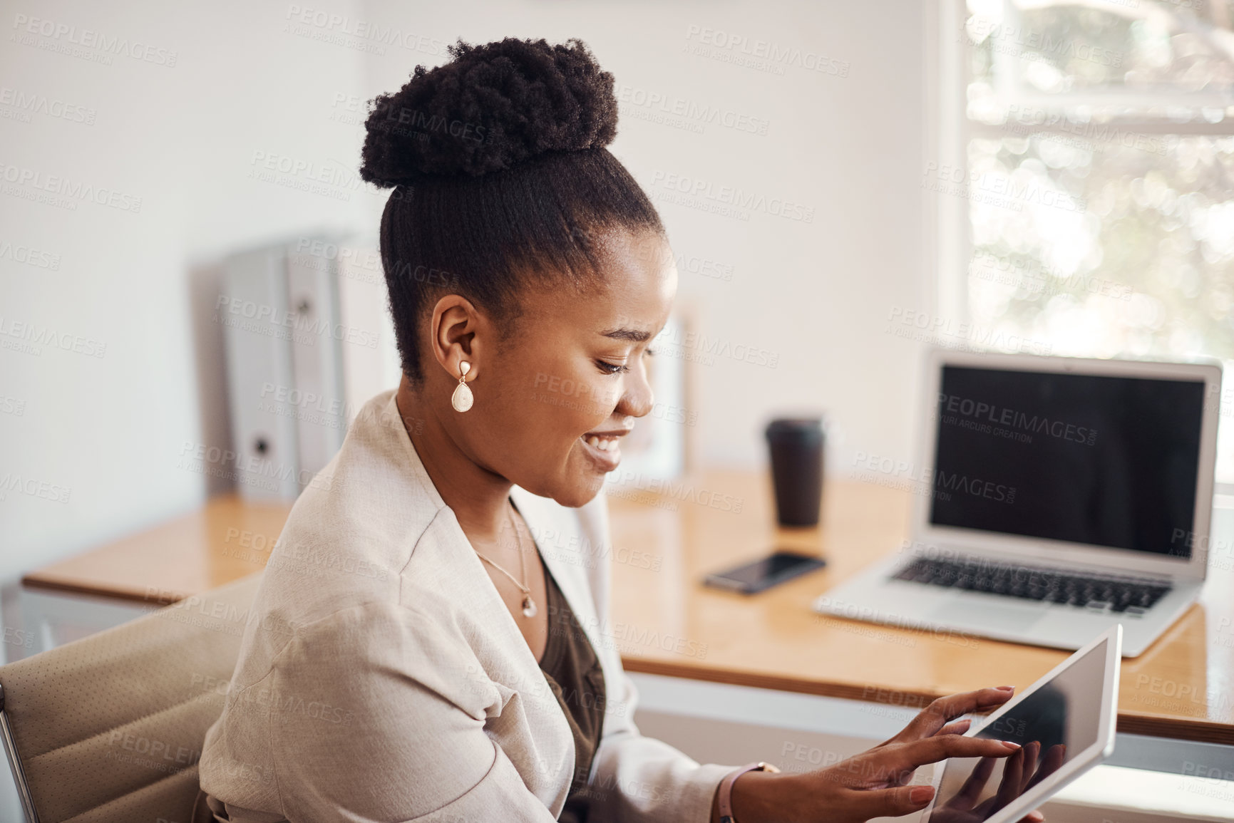 Buy stock photo Shot of a young businesswoman using a digital tablet in an office