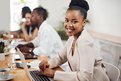 Buy stock photo Portrait of a young businesswoman using a laptop in an office with her colleagues in the background