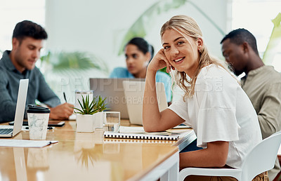 Buy stock photo Cropped portrait of an attractive young businesswoman sitting with her colleagues during a discussion in the office