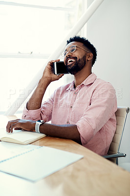 Buy stock photo Cropped shot of a handsome young businessman sitting alone and using his cellphone in the office