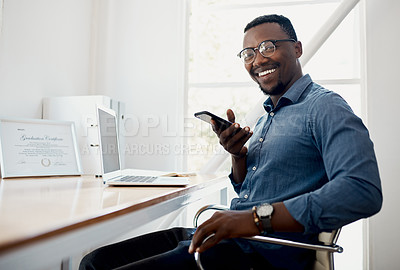 Buy stock photo Cropped portrait of a handsome young businessman sitting alone in the office and sending voice notes on his cellphone