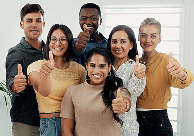 Buy stock photo Cropped portrait of a diverse group of businesspeople standing together and making a thumbs up gesture in the office