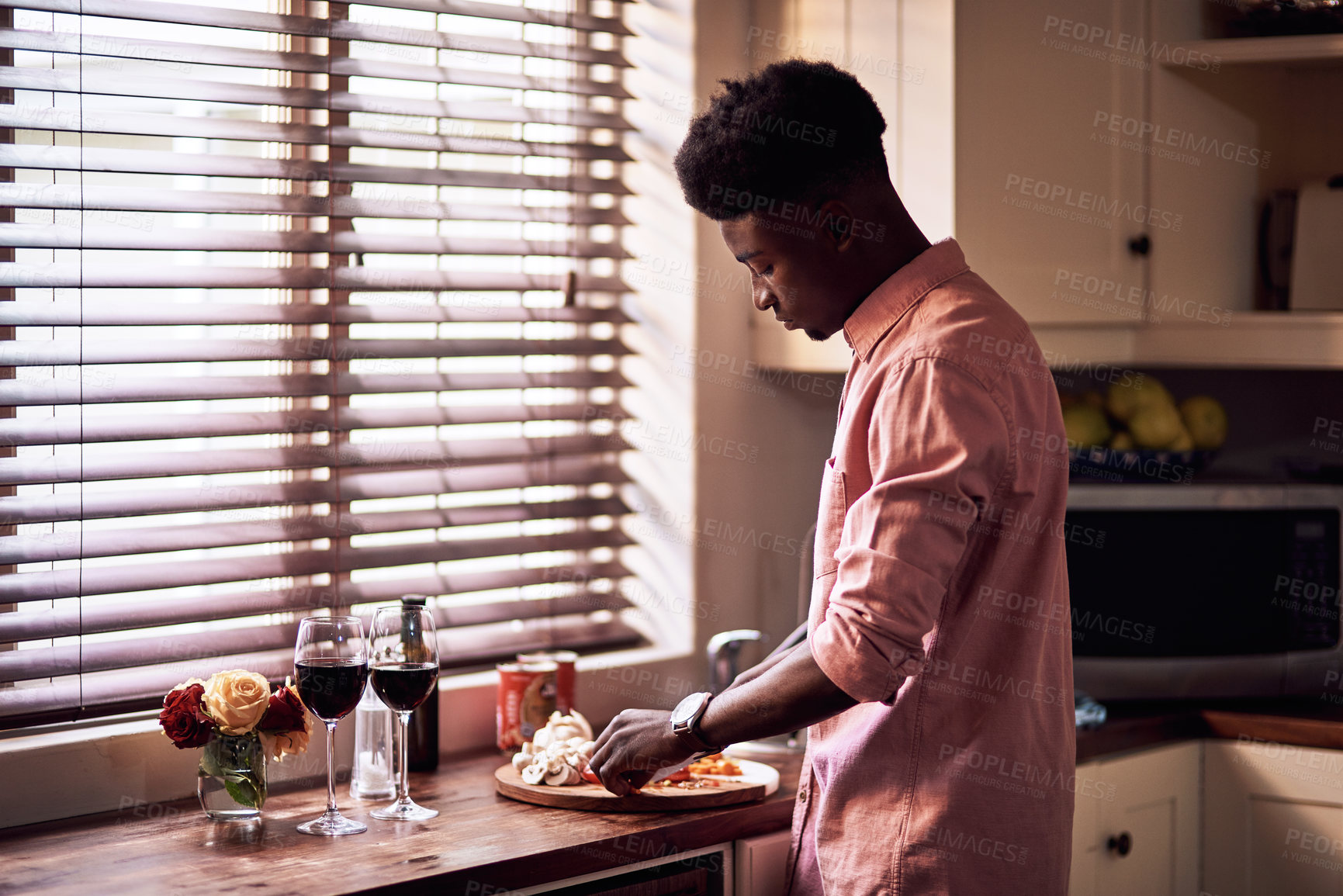 Buy stock photo Cropped shot of handsome romantic young man preparing a meal on Valentine's day at home