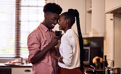Buy stock photo Cropped shot of an affectionate young couple drinking wine together in their kitchen at home