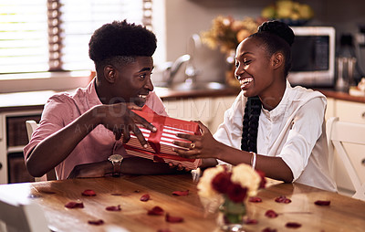 Buy stock photo Cropped shot of an affectionate young man giving his wife a wrapped gift on Valentine's day at home