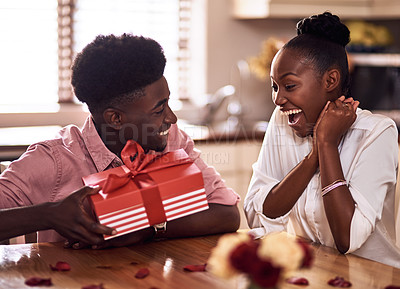 Buy stock photo Cropped shot of an affectionate young man surprising his wife with a wrapped gift on Valentine's day at home