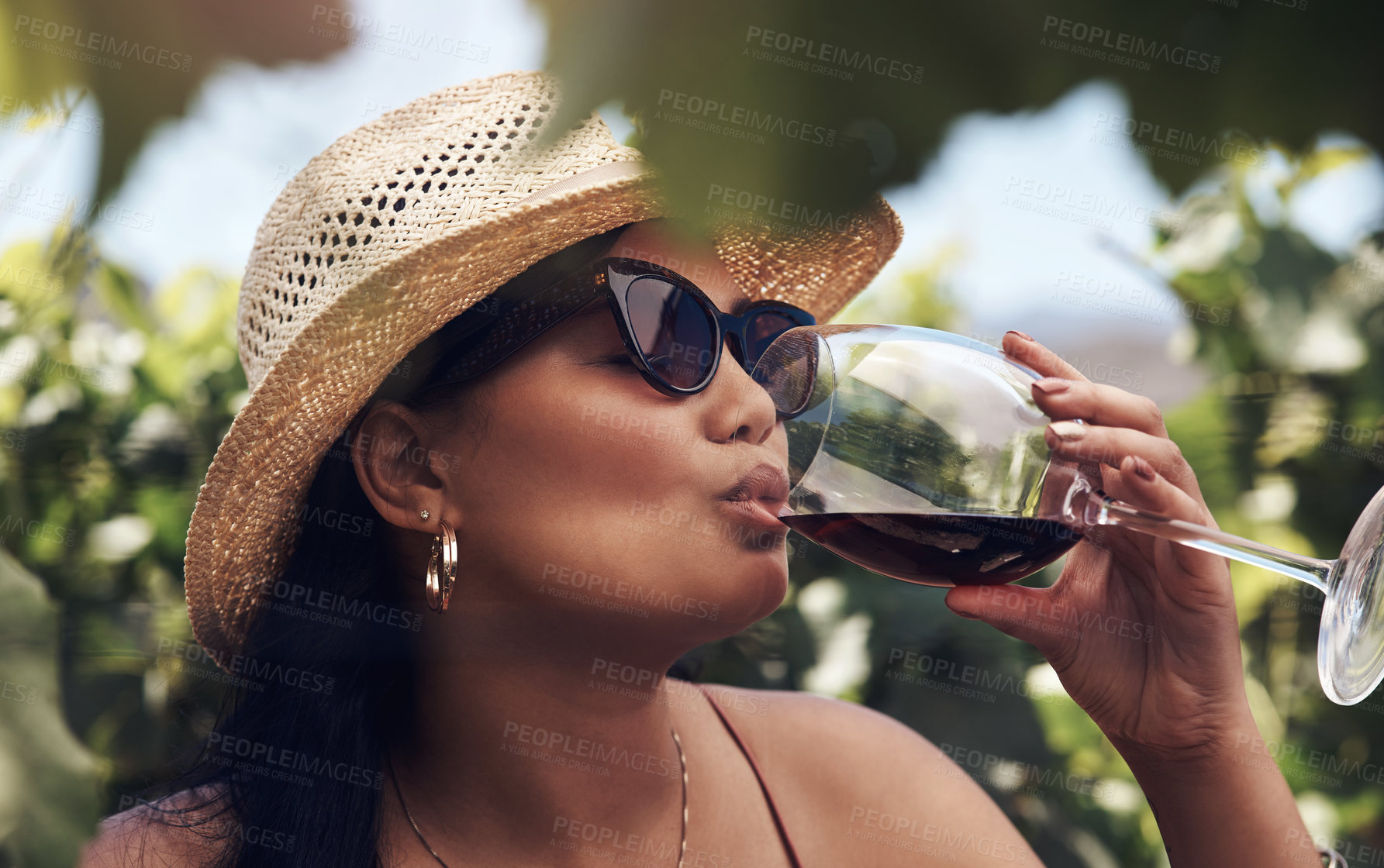 Buy stock photo Cropped shot of a beautiful young woman having a glass of wine outdoors