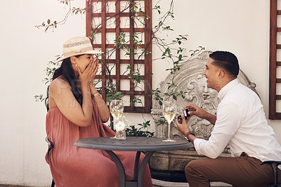 Buy stock photo Shot of a man proposing to his girlfriend while out on a date