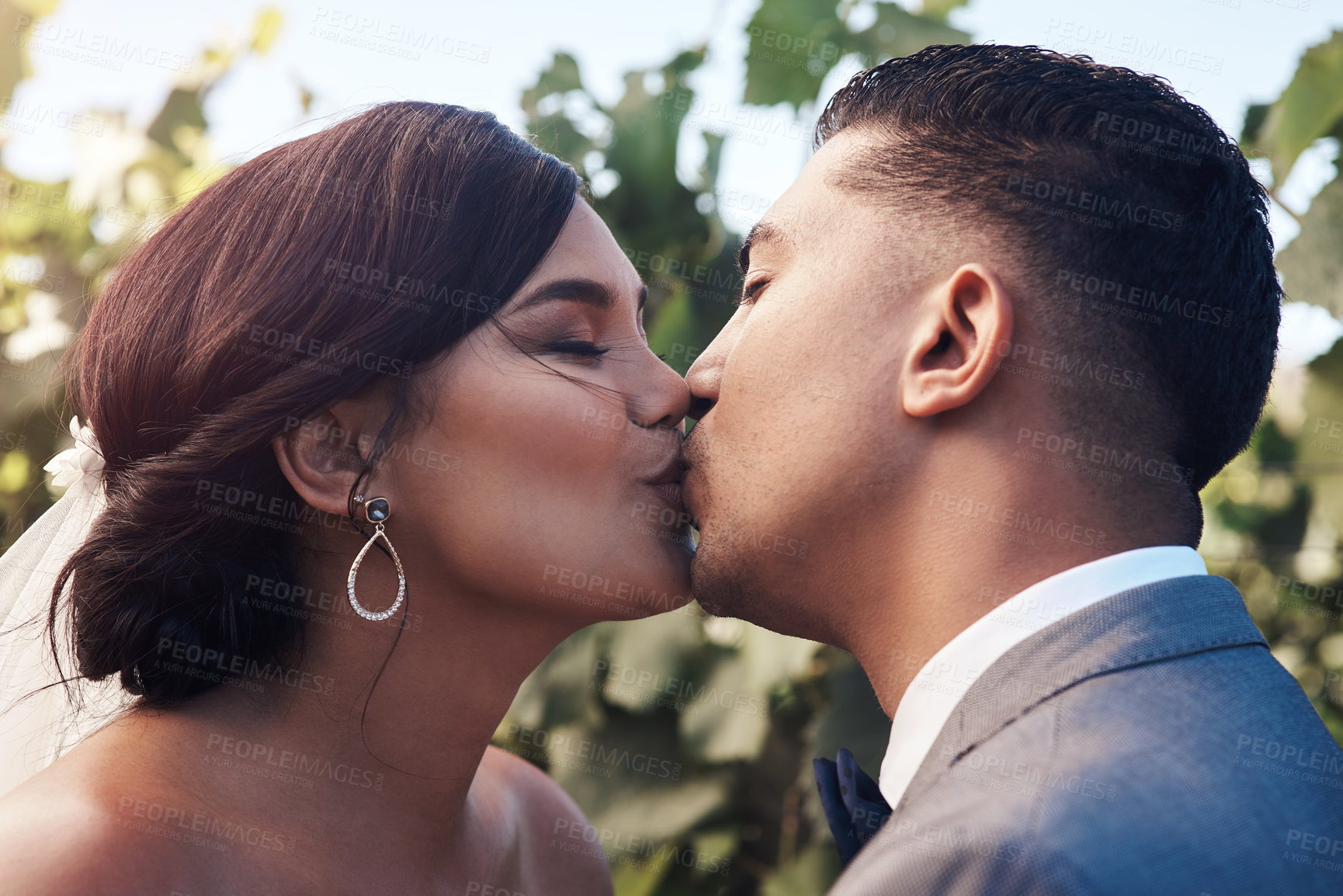 Buy stock photo Couple, outdoor and kiss on wedding for love, commitment and promise for affection or emotional connection with care. Man, woman and intimate for celebration in garden for unity, safety and security.