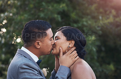 Buy stock photo Cropped shot of a young couple sharing a kiss on their wedding day