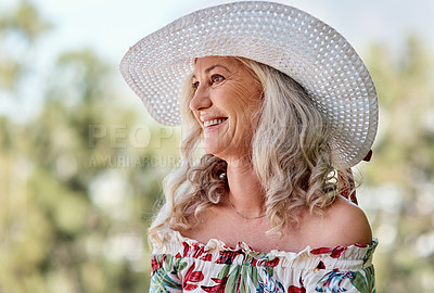 Buy stock photo Cropped shot of an attractive senior woman smiling while sitting outdoors on a summer's day