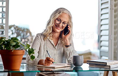 Buy stock photo Cropped shot of an attractive senior businesswoman taking a phonecall while working from home