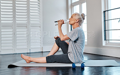 Buy stock photo Shot of a mature woman practicing yoga while having a drink of water inside of a studio during the day