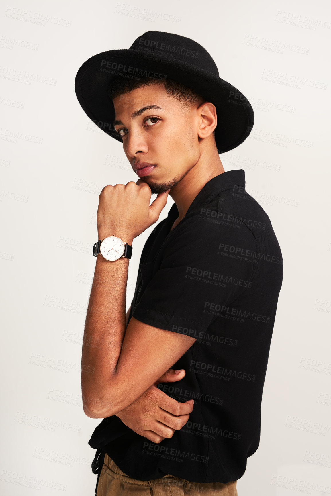 Buy stock photo Portrait of a handsome young man wering a hat while posing against a grey background