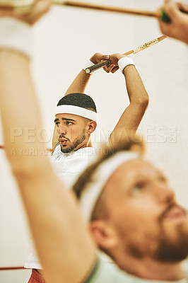Buy stock photo .Shot of two young men stretching before playing a game of squash