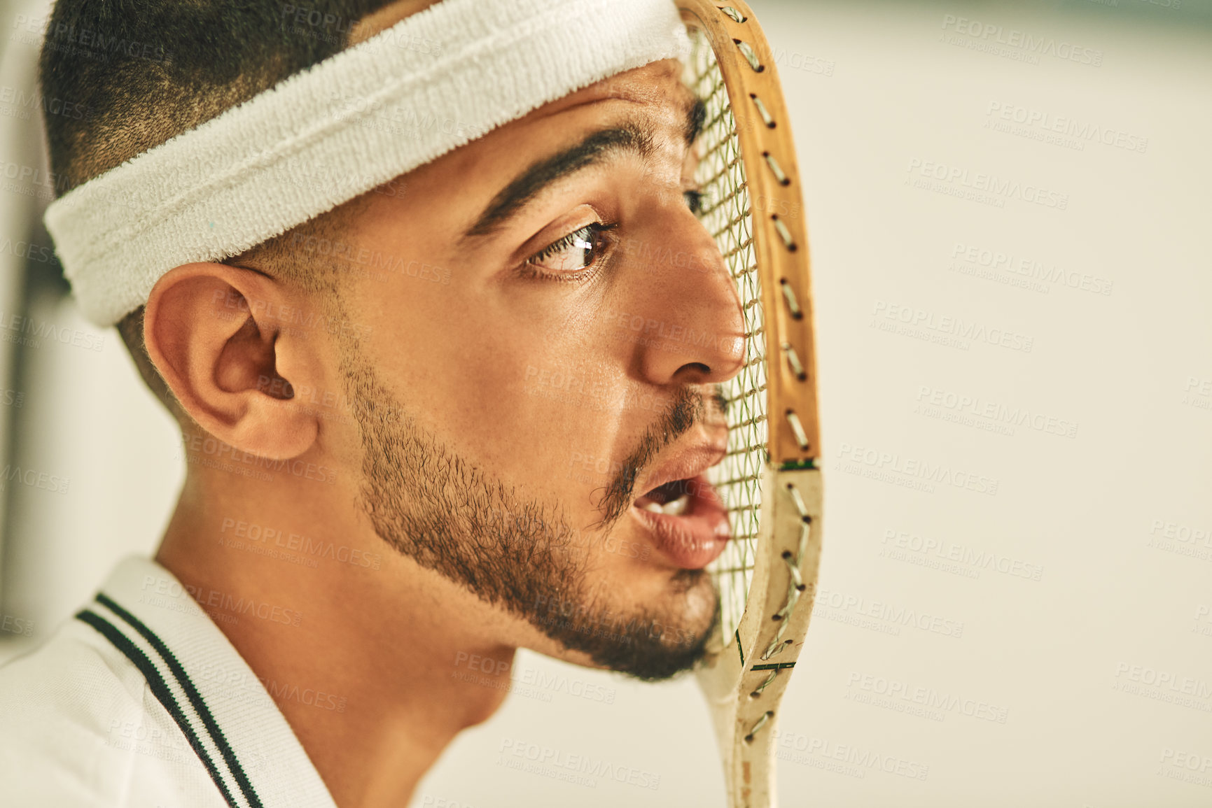 Buy stock photo Shot of a young man pressing his face up against his squash racket
