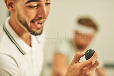 Buy stock photo Shot of a young man holding a squash ball at a sports venue