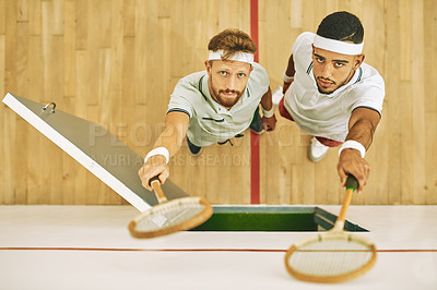 Buy stock photo High angle shot of two young men holding up their rackets at a squash court
