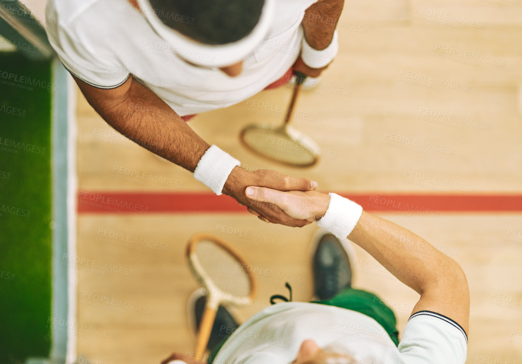 Buy stock photo High angle shot of two young men shaking hands at a squash court