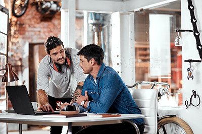 Buy stock photo Cropped shot of two young businessmen working together in an office inside their workshop