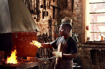 Buy stock photo Blacksmith, fire and a black man welding metal in a workshop for manufacturing or industrial design. Factory, melting or industry with a male welder in metalwork using a hot flame to melt material