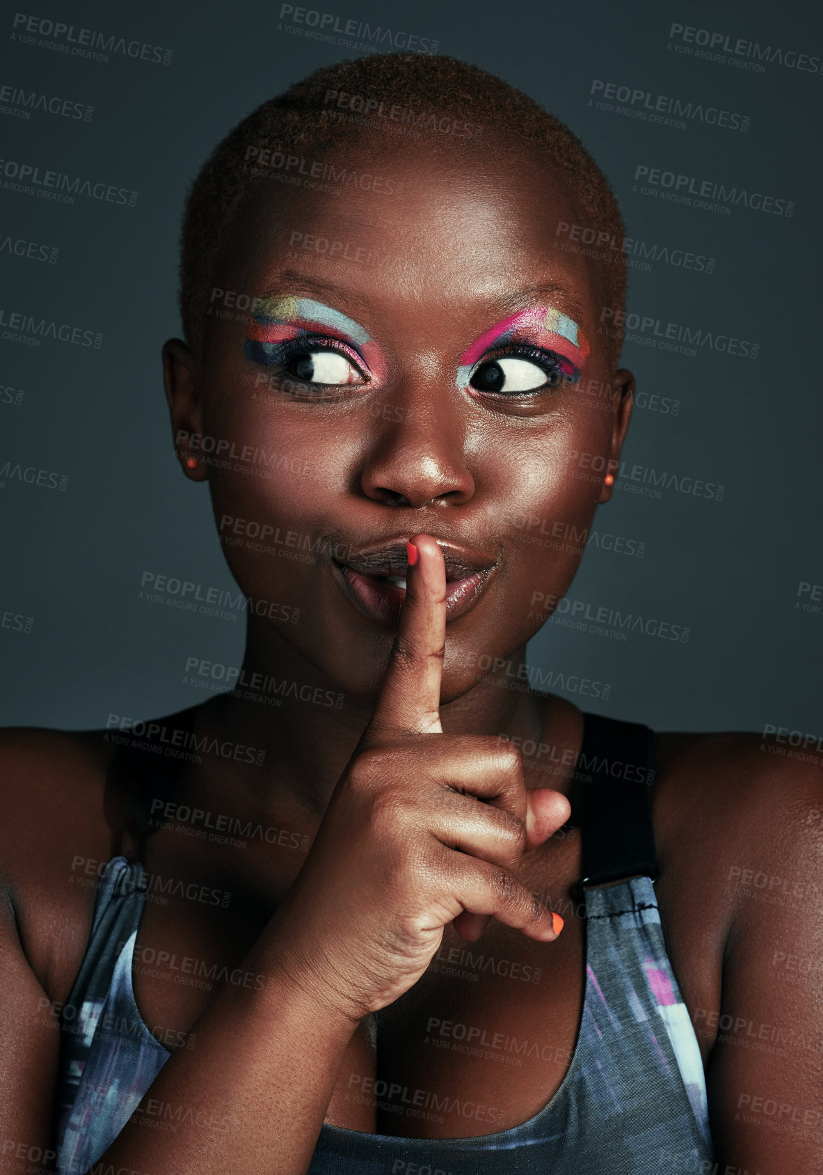 Buy stock photo Cropped shot of a beautiful young woman posing with her finger on her lips against a grey background