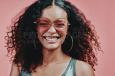 Buy stock photo Shot of a beautiful young woman wearing sunglasses while posing against a pink background