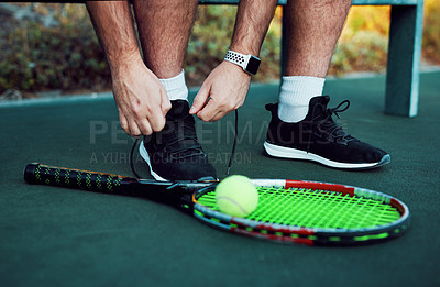 Buy stock photo Closeup shot of an unrecognisable man tying his laces on a tennis court