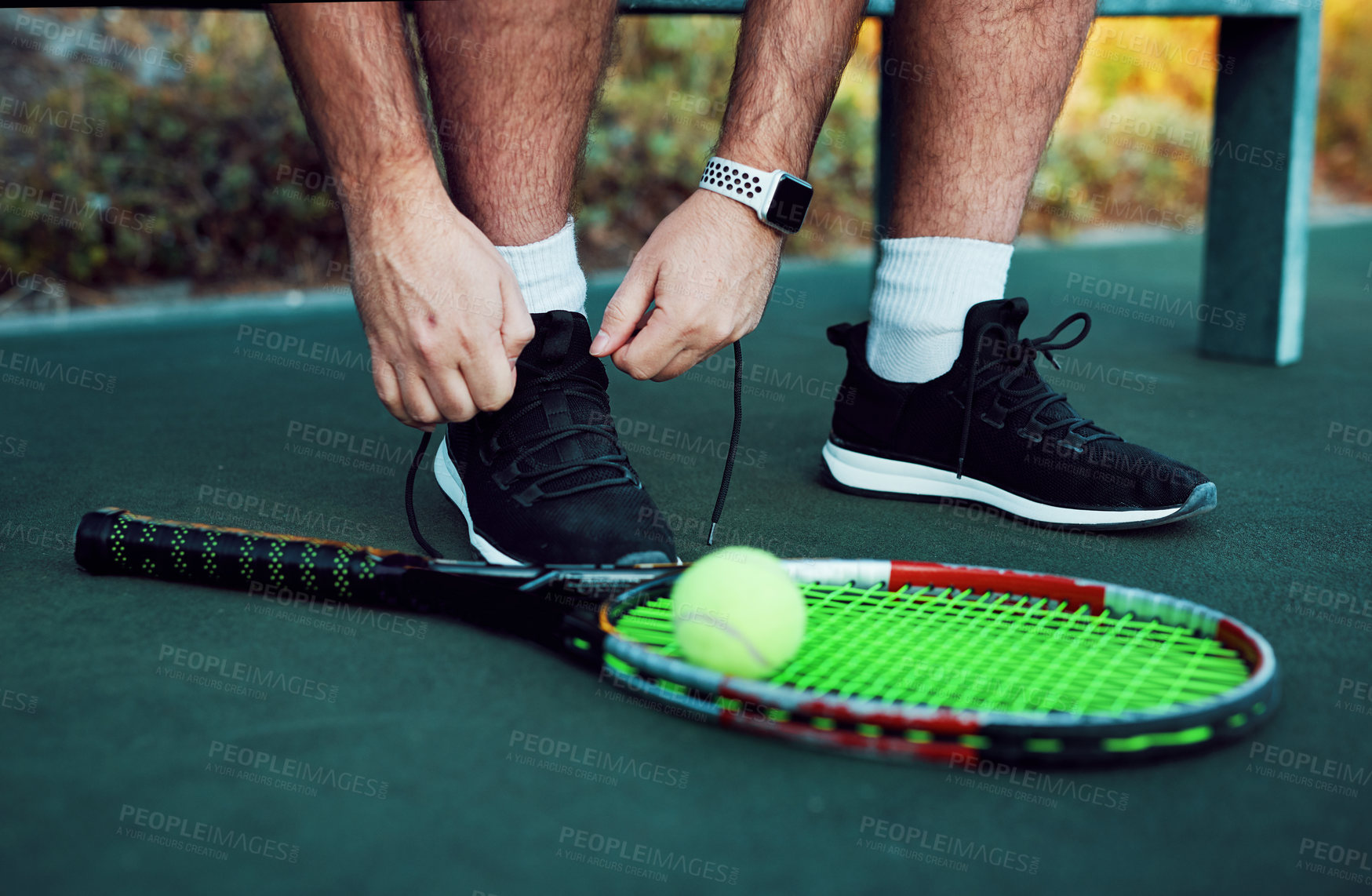 Buy stock photo Closeup shot of an unrecognisable man tying his laces on a tennis court