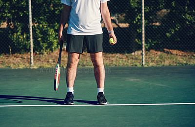 Buy stock photo Closeup shot of an unrecognisable man holding a tennis racket and ball on a tennis court